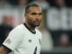 Joueur de football en maillot blanc sur le terrain.