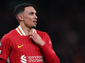 Joueur de football en maillot rouge sur le terrain.