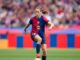 Joueuse de football contrôlant le ballon sur le terrain.