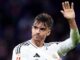 Footballeur levant la main en maillot blanc.