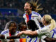 Joueuses de Lyon célébrant un but ensemble.