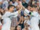 Deux joueurs de football se tapent dans les mains.