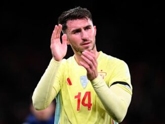 Joueur de football applaudissant sur le terrain.