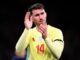 Joueur de football applaudissant sur le terrain.