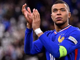 Joueur de football applaudissant sur le terrain.