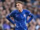 Joueur de football en maillot bleu sur le terrain.