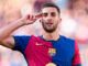Footballeur saluant en maillot FC Barcelone.