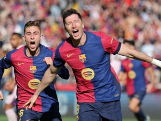 Deux footballeurs célébrant un but sur le terrain.