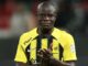 Joueur de football applaudissant en maillot jaune et noir.