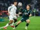 Deux joueurs disputent un ballon de football.