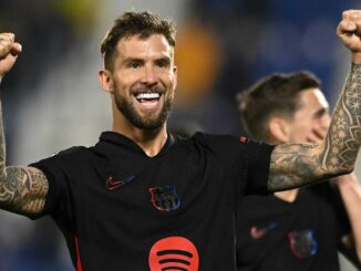 Joueur de football célébrant victoire sur le terrain.
