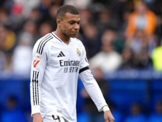 Joueur de football en maillot blanc sur le terrain.