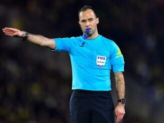 Arbitre de football sur le terrain en action.