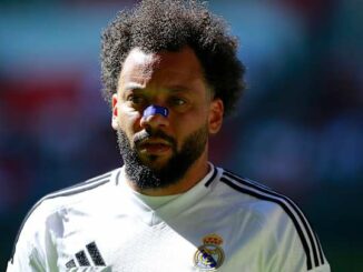 Joueur de football en maillot blanc sur le terrain.