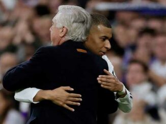 Deux personnes s'embrassant sur un terrain de football.
