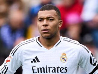 Joueur de football en maillot blanc sur le terrain.