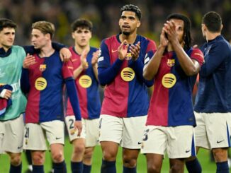 Joueurs de football en train d'applaudir sur le terrain.