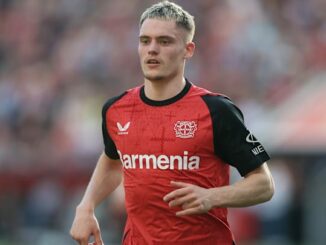 Joueur de football en maillot rouge sur le terrain.