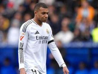 Footballeur en plein match avec maillot blanc.