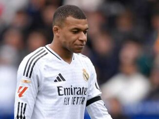 Joueur de football en maillot blanc sur le terrain.