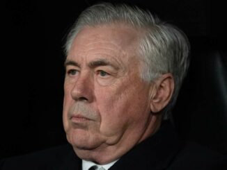 Homme âgé aux cheveux gris, regard sérieux.