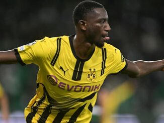 Joueur de football en action, maillot jaune et noir.