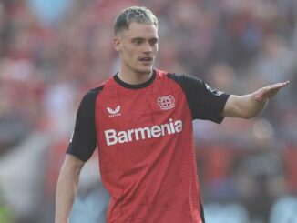 Joueur de football en maillot rouge sur le terrain.