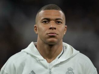 Homme en sweat blanc, regard sérieux.