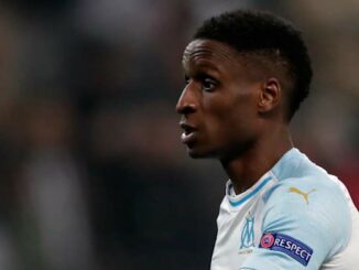 Joueur de football en maillot blanc sur le terrain.