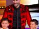 Homme en costume rouge avec deux enfants heureux.