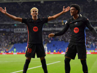 Deux joueurs de football célèbrent sur le terrain.