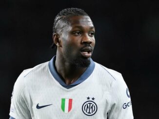 Joueur de football en maillot blanc sur le terrain.