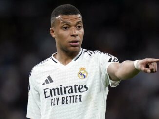 Joueur de football en maillot blanc pointant du doigt.