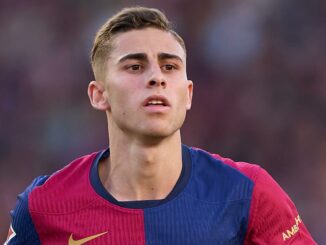 Joueur de football en maillot bordeaux et bleu.
