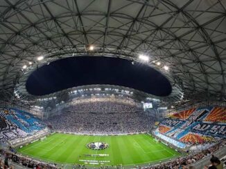 Stade rempli de supporters pendant un match de foot.