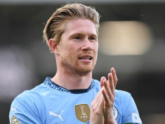 Joueur de football en train d'applaudir sur le terrain.