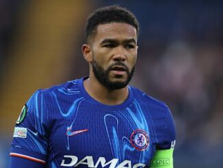 Joueur de football portant maillot bleu sur le terrain.