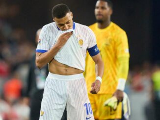 Joueur de football en maillot blanc sur le terrain.