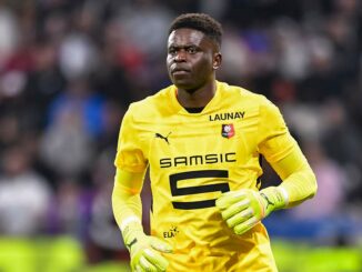 Gardien de but en maillot jaune sur le terrain.