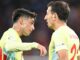Deux footballeurs discutant sur le terrain.