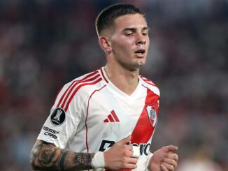 Joueur de football en maillot blanc sur le terrain.