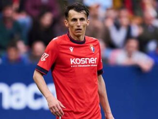 Joueur de football en maillot rouge sur le terrain.