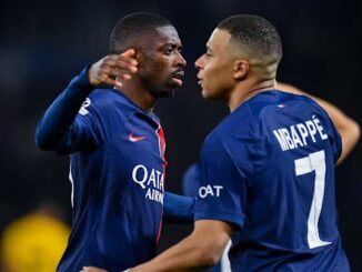 Deux footballeurs en maillot du PSG s'embrassent.