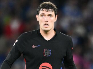 Joueur de football en maillot noir sur le terrain.