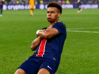 Joueur de football célébrant un but sur le terrain.