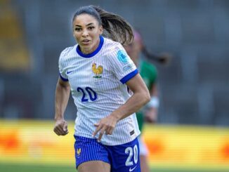 Footballeuse française courant sur le terrain.