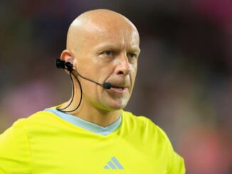 Arbitre de football avec un micro sur le terrain.