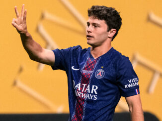 Joueur de football en maillot bleu levant trois doigts.