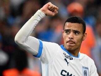 Joueur de football en maillot blanc célébrant.