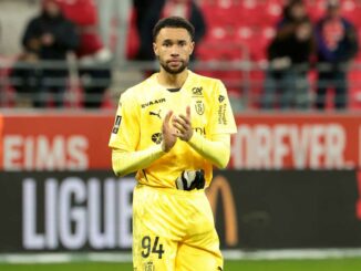 Joueur de football applaudissant sur le terrain.